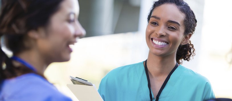 Medical employee smiling at a coworker. 
