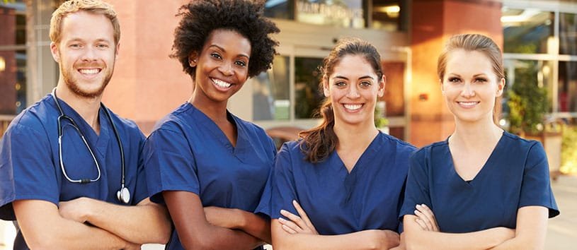 Four Practical Nursing students standing together.